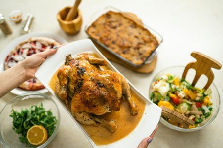 Savory roasted chicken served with fresh salad and baked side dishes.