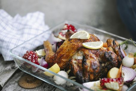 Succulent roasted chicken with vegetables and lemon slices, perfect for a savory meal.