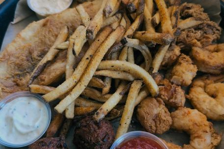 A mouthwatering assortment of fried seafood, coleslaw, and tartar sauce.