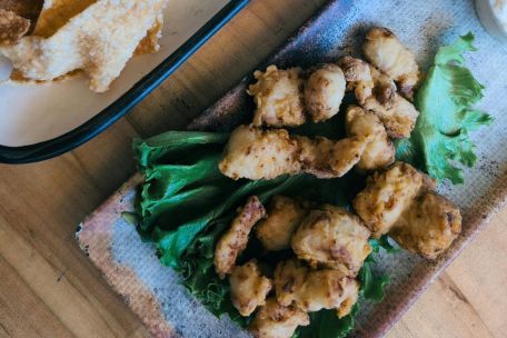 A delectable seafood platter with fried shrimp, chips, and dipping sauce, perfect for a savory meal.