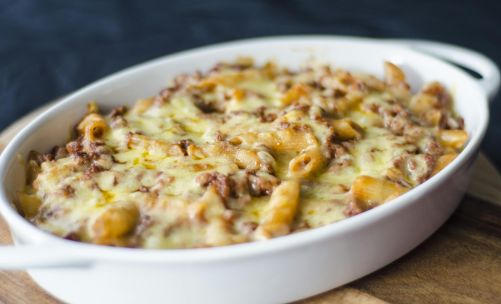 Close-up of a homemade baked macaroni and cheese in a white dish. Perfect comfort food for lunch or dinner.