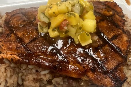 Delicious grilled salmon served with roasted vegetables and herb sauce.