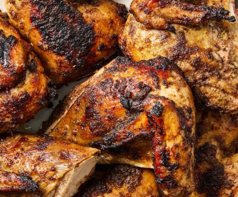 A group of friends toasting drinks in a warm, cozy indoor setting with food and flowers.