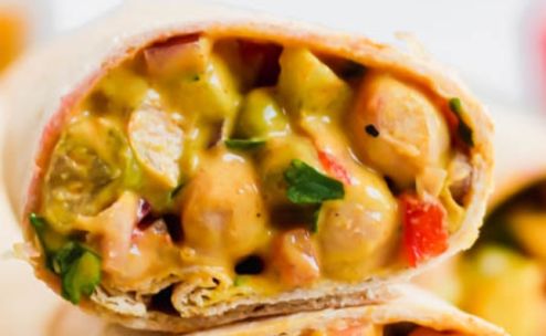 Tasty chicken wrap filled with fresh vegetables on a wooden board.